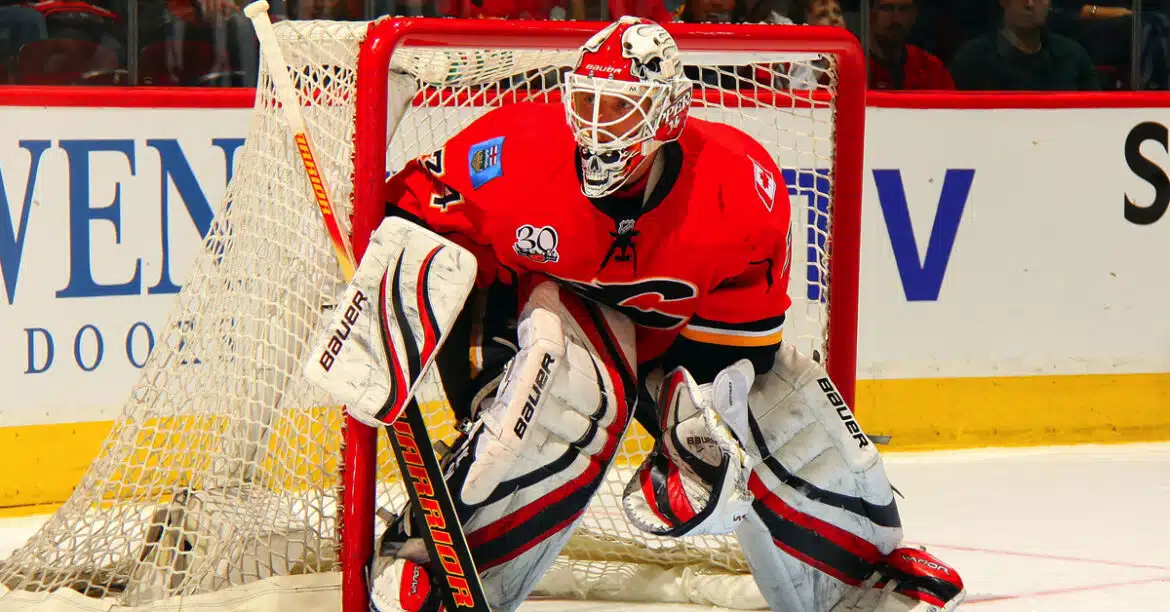 Ice hockey goalie in full gear defending the net.