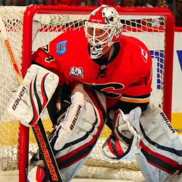Ice hockey goalie in full gear defending the net.