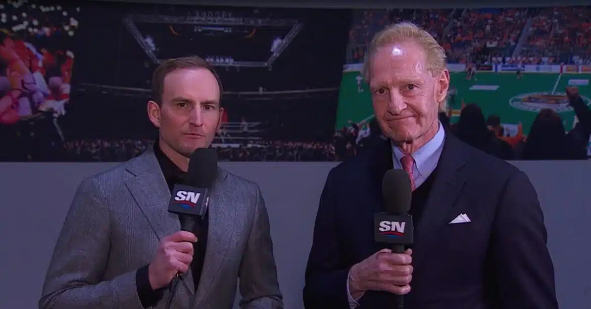 Two men holding microphones in a studio setting.