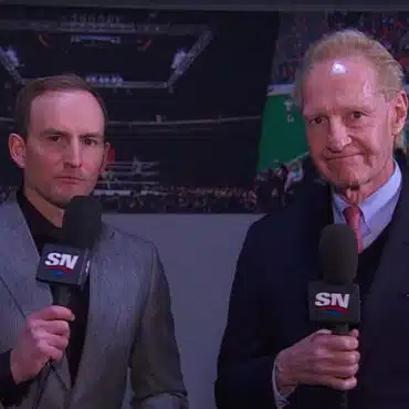 Two men holding microphones in a studio setting.