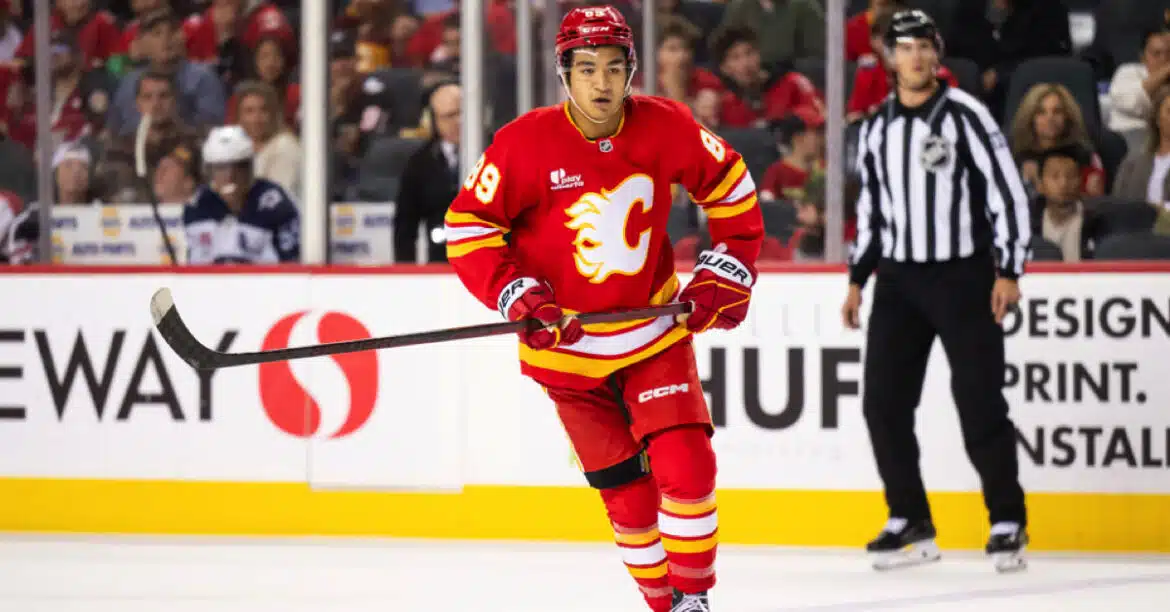 Hockey player in red Calgary Flames uniform on ice during a game.