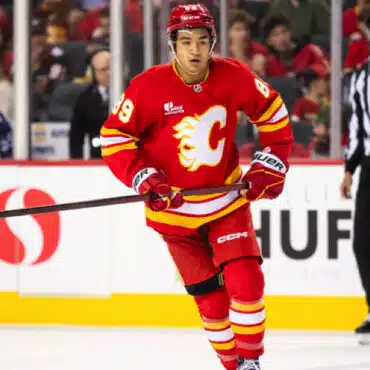 Hockey player in red Calgary Flames uniform on ice during a game.