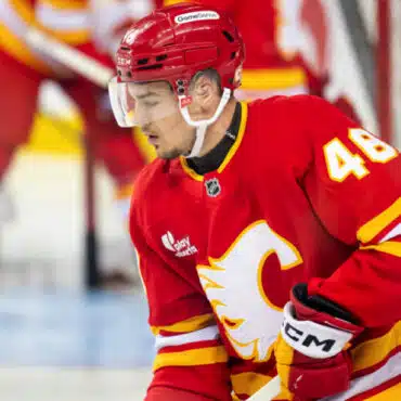 Ice hockey player in red Calgary Flames uniform on the ice.