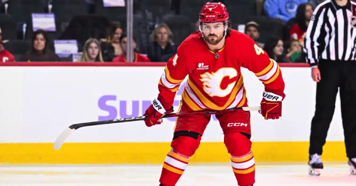 Hockey player in red Calgary Flames uniform on ice rink.