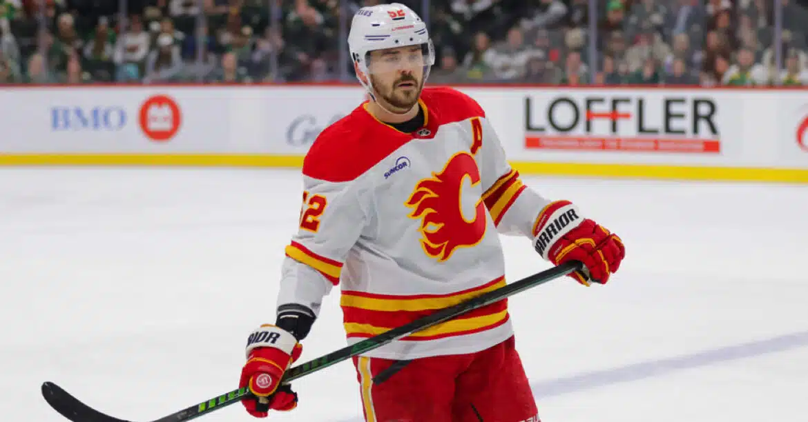Hockey player in a Calgary Flames uniform on ice.