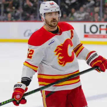 Hockey player in a Calgary Flames uniform on ice.